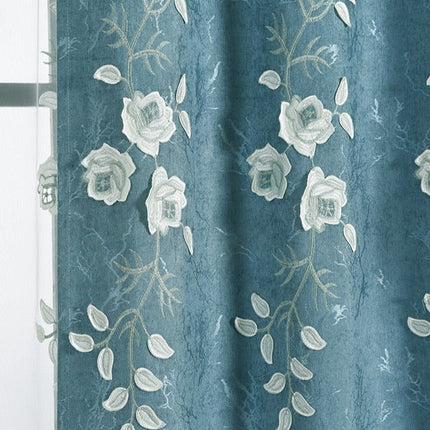 Niebieska zasłona z białym haftem kwiatowym