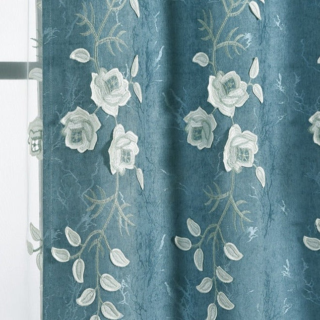 Niebieska zasłona z białym haftem kwiatowym