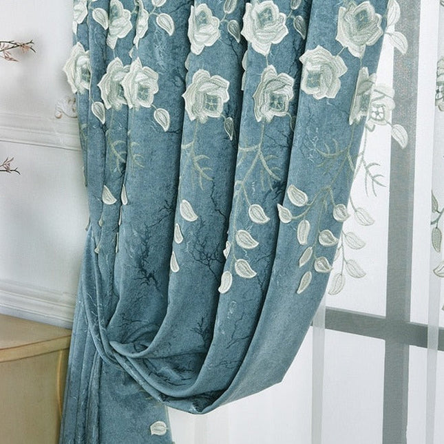 Niebieska zasłona z białym haftem kwiatowym