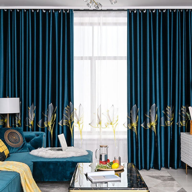 Niebieska welurowa zasłona w haftowane kwiaty.