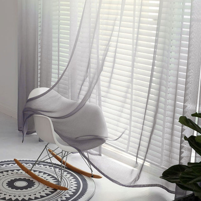 Szara zewnętrzna firana ombre na szelkach.