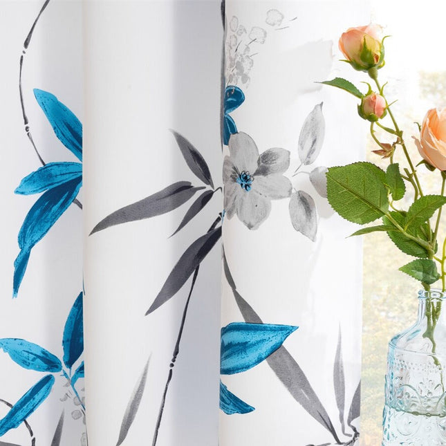 Biała zasłona w niebieskie kwiatowe wzory.