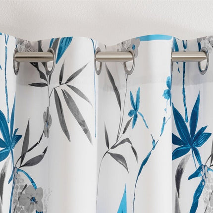 Biała zasłona w niebieskie kwiatowe wzory.