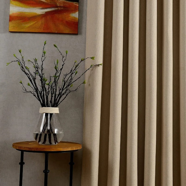 Gładka beżowa zasłona zaciemniająca na przelotkach.