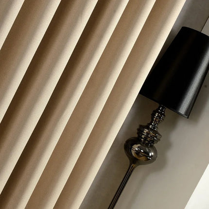 Gładka beżowa zasłona zaciemniająca na przelotkach.