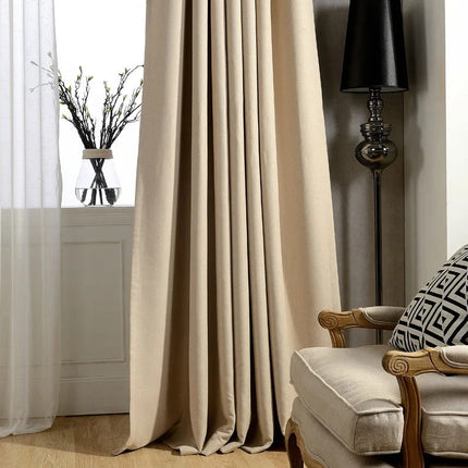 Gładka beżowa zasłona zaciemniająca na przelotkach.