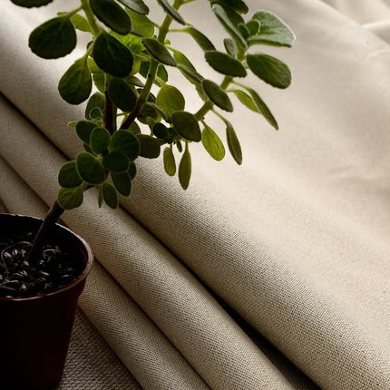 Gładka beżowa zasłona zaciemniająca na przelotkach.