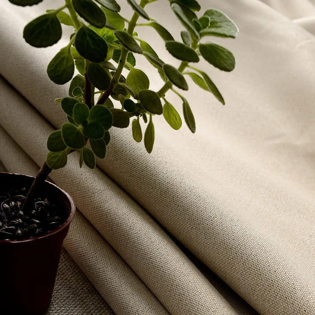 Gładka beżowa zasłona zaciemniająca na przelotkach.